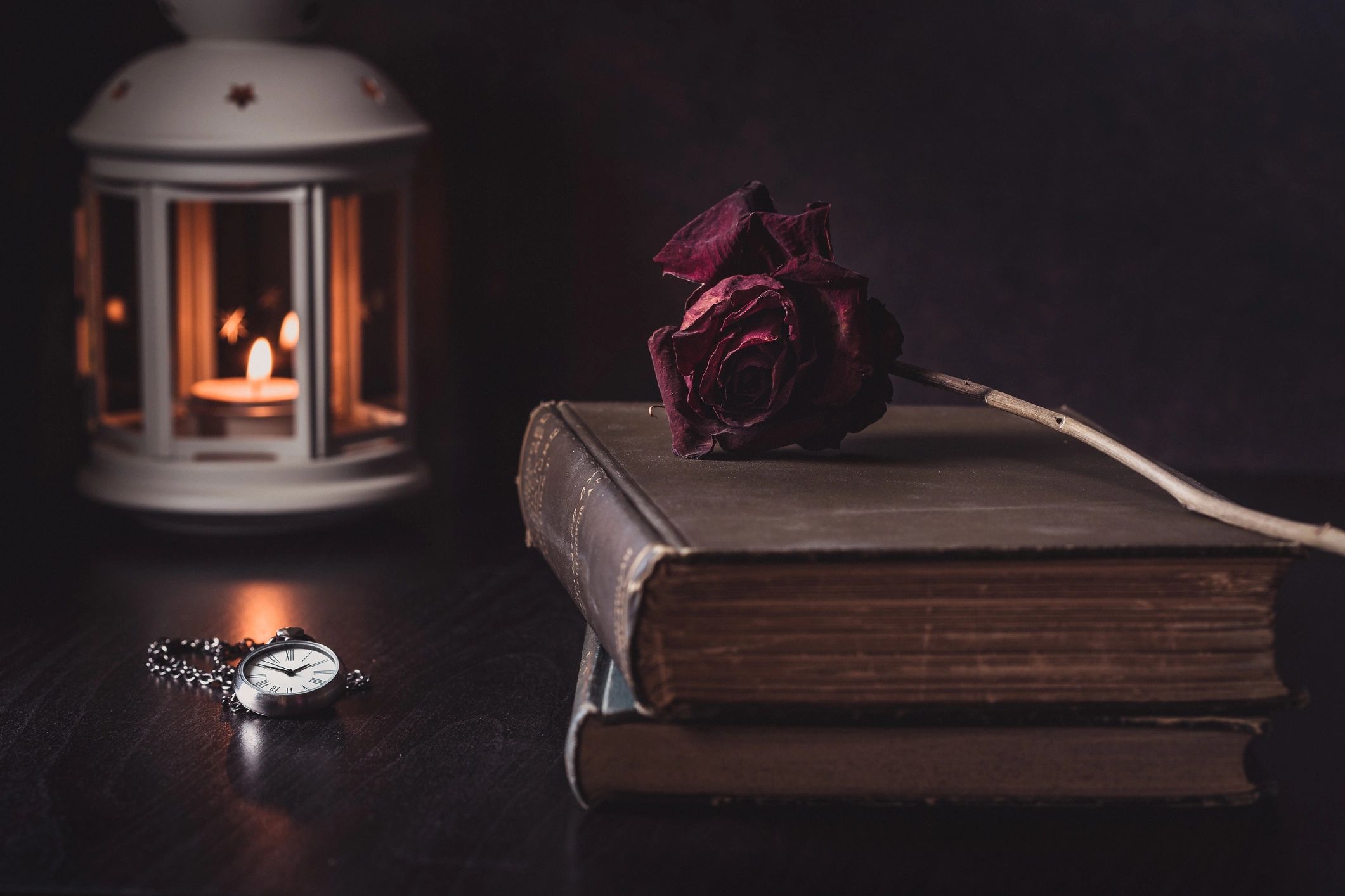 Vintage still life with a rose resting on old books